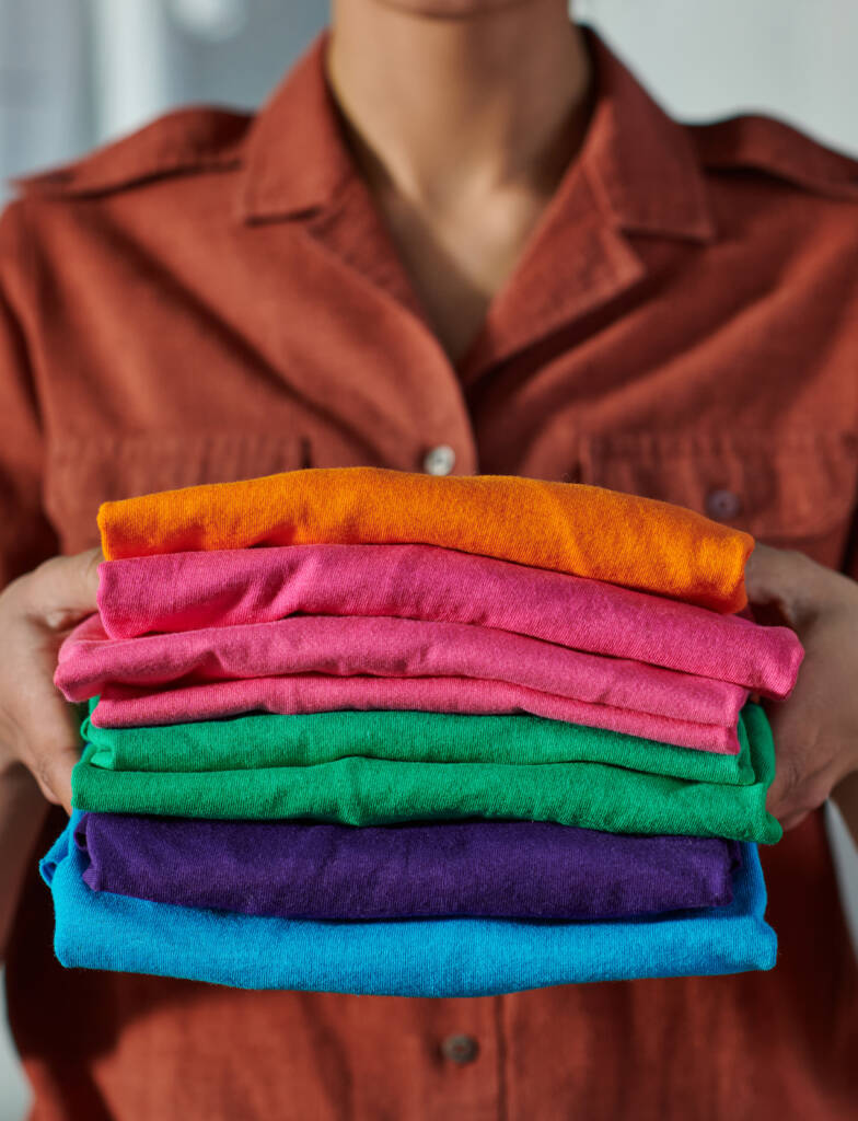 Woman holding neatly folded clothes at Tidy Loads Laundry providing residential laundry service in Jacksonville, Nocatee, St. Johns